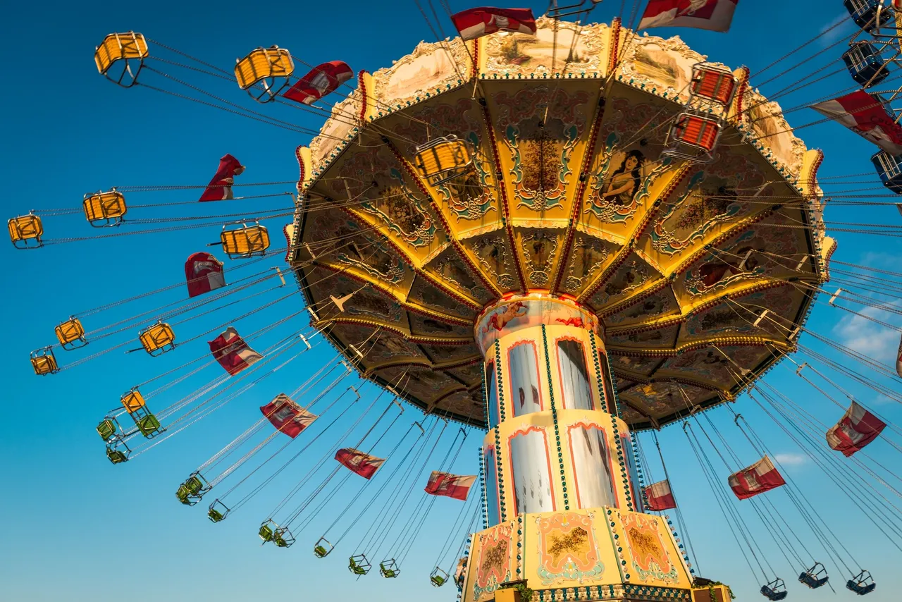 A ferris wheel with many flags flying in the air.