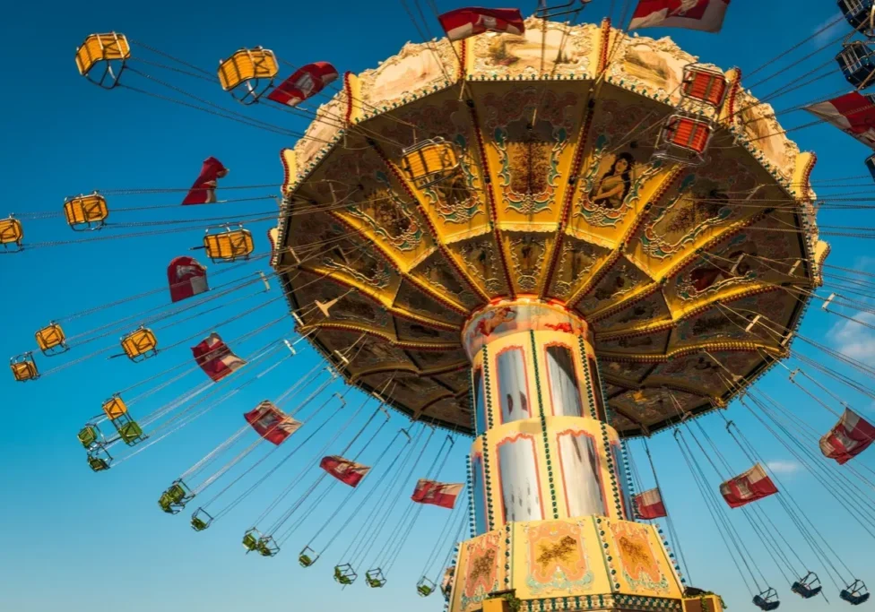 A ferris wheel with many flags flying in the air.